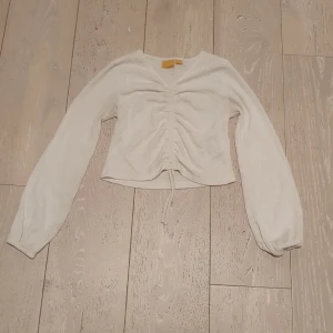 Ginatricot långärmad topp med utsvängda ärmar och snörning imitten. - I använt skick. Strl 146 - 152.