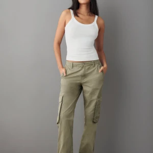 Gina tricot cargobyxor  - Mörkgröna cargobyxor/ jeans med fickor på benen. Straight leg och Low waisted Jättefint skick och använda fåtal gånger. Säljs pga att de ej komme till användning. Nypris 499 säljs för 100, pris kan diskuteras 💞