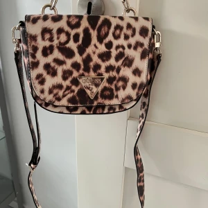 Leopard mönstrad väska från Guess!🐆💝 - Säljer min leopardmönstrade väska från Guess. Jättefin och smidig väska då den har axelband som även går att ta av. Hur fin som helst! Nyskick💕