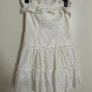 En vit klänning som jag köpte på Zara som mamma sedan sydde om till en snygg klänning utan axlar med sötaste volangerna
