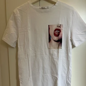 T-shirt  - Vit t-shirt i nyskick i från Na-kd med tryck på vänster sida.🤍