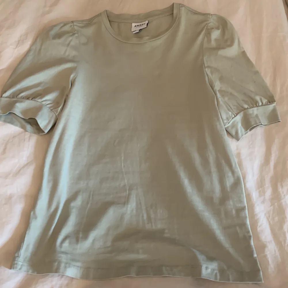 Säljer denna super fin grön t-shitr med puffärmar från Vero Moda i storlek XS. Jag har använt den 1-2 så den är i bra skick💕. T-shirts.