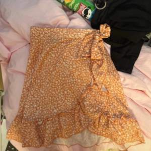Jättesöt orange blommig kjol med volang som tyvärr inte kommer till användning längre! Passar även S!