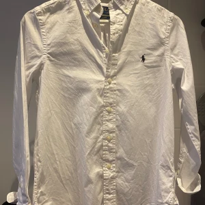 Polo Ralph lauren skjorta  - VIT SLIM FIT COTTON OXFORD SHIRT - KILLE i väldigt bra skick, som ny. Användes bara 1 gång på skolavslutningen. Helt skadefritt 