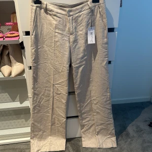 Linné kostymbyxa - Dessa beiga linnekostymbyxorna från design by si är aldrig använda och prislappen sitter kvar, storlek M, långa i benen. Nypris 600 & jag säljer dom för 450.