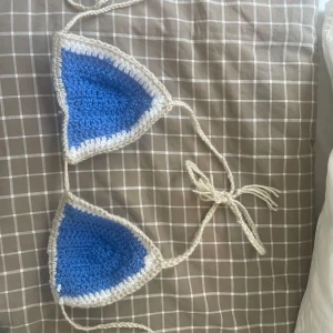 Handvirkad bikinitopp - En superfin blå-vit virkad bikinitop som ger riktigta utomlands-vibes. garnet är vattenfast så det tål att simma i. Den är högt täckande och supettrendig. Skriv för fler bilder