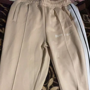 PALM ANGELS BYXOR - Säljer ett par beigea palm angels byxor i storlek M, ändast prövade och säljer pga att de ej passade. Skick 10/10. Om det är många som är intresserade så kan priset eventuellt stiga. Hör av er om ni har några funderingar!