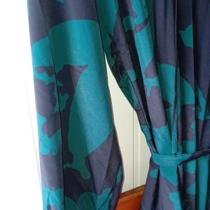 Kort klänning/tunika svart/grön - Kort vid modell. Knytband i midjan.