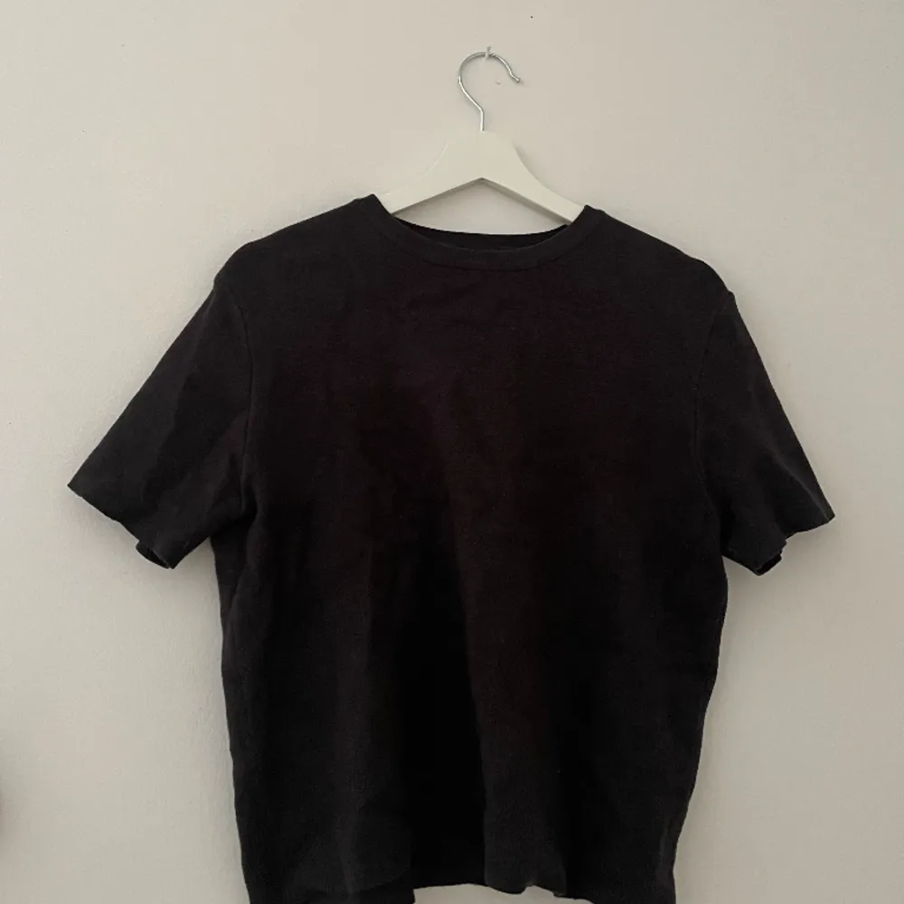 En stickad t-shirt från en gammal Zara kollektion. Menad som en tajt nästan magtröja, men denna är i L och blir då en perfekt längd och passform för dom som är S. Den är inte helt svart, utan lite tvättad svart färg . Stickat.