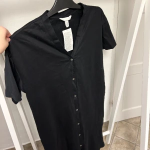 Svart klänning med knappdetaljer  - Svart klänning med knappdetalj från Hm i xs. Aldrig använd! 89kr