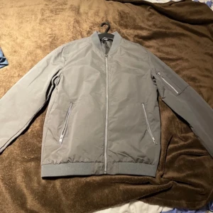 Bomber Jacka  - Grå bomber jacka från Jack and Jones. Aldrig använd men har inte prislap kvar. Storlek M 