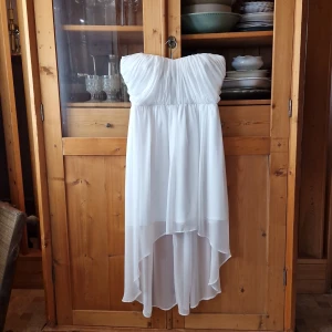 Fin vit bandeuklänning med längre bakstycke - Vacker vit bandeuklänning med längre tyg baktill. Endast använd 1 gång! Jättefin till bröllop, student och skolavslutning osv. Storlek 36🌻 tycker du jag är dyr så pröva buda. :)