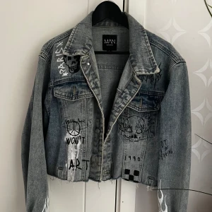 Jeans jacka - Kroppad Blå jeans jacka med tryck på. Några år gammal men bara använd några gånger. Storlek L