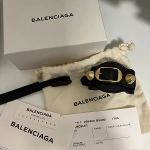 Balenciaga armband  - Svart Balenciaga läderarmband med guldiga nitar.  I mycket fint skick utan defekter eller andra anmärkningar, alla tillbehör på bilden medföljer.  Längd 26cm