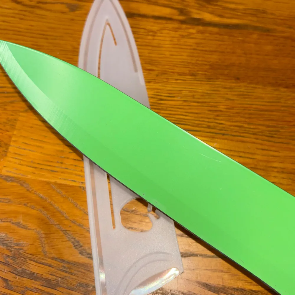 Helt ny aldrig använd grön kökskniv med fodral. Övrigt.