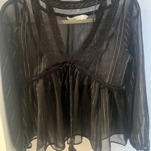  Blus - En svart blus med guldiga detaljer. Köpte den från secondhand men den har aldrig kommit till användning.