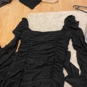 Svart klänning - Svart lång klänning med genomskinliga armar. Klänningen är endast testad. Köparen står för frakten