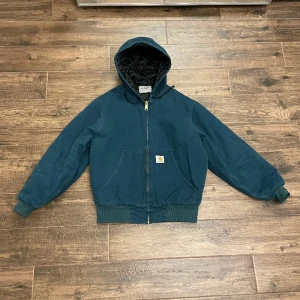 Blå vintage Carhartt jacka med luva - Längd: 62 cm Bredd: 50 cm Sitter väldigt oversized, storleken som står på jackan är XS men den sitter mer som en S eller M