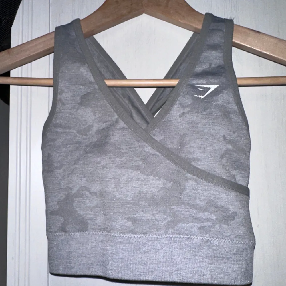 Tag size S, but RUNS SMALL!!!! I wrote XS, but the tag is S. Please be very aware of this sizing. Grey sports bra with back cut outs and pad inserts. Logo print slightly cracked. Gently used condition with some fuzz. . Toppar.