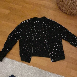 Tunn kofta med dragkedja - Jätte söt tunn kofta med dragkedja som har rosa och vita prickar på. På båda ärmarna finns ett vit sträck på hela armen.(skriv privat om du känner dig intresserad)