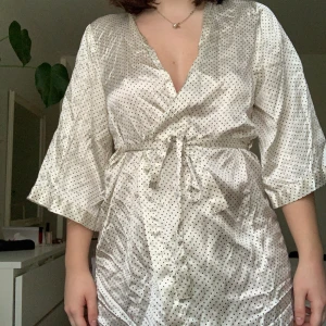 Kimono - En kort krämvit kimono med svarta prickar. Bra skick. 