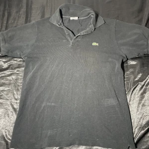 Lacoste Piké - Lacoste piké i storlek S, hyfsat tight i ärmarna, saknar en knapp, använd ett fåtal gånger.