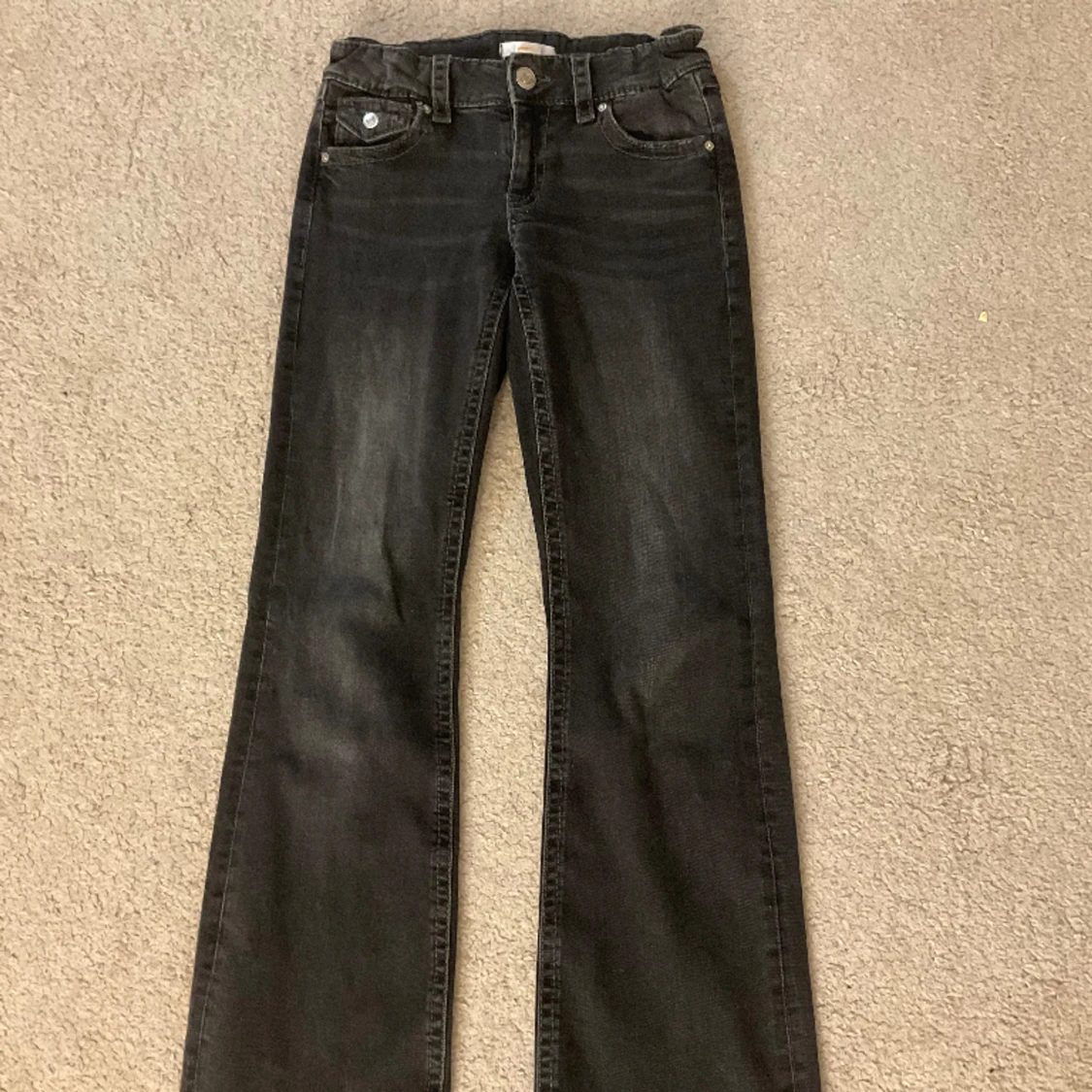 Mörkgrå bootcut jeans med knappfickor