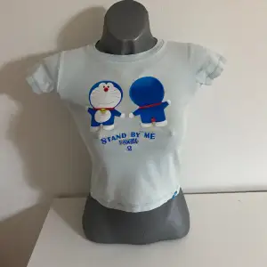 Ljusblå T-shirt med gulligt tryck, passar bra på s och xs