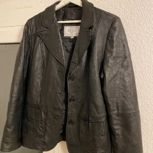 Läderjacka/Skinnjacka Vintage - Äkta vintage läderjacka. Köpt i vintagebutik i Madrid. Mycket bra skick, inga defekter, märken eller fläckar. Inköpt för över 1.000kr. Pris kan diskuteras. Fraktavgift tillkommer. Strl: XL (Dock väldigt liten i storleken, som en S)