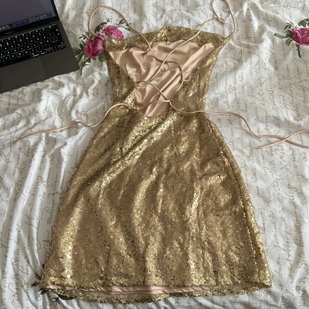 Guld glittrig klänning från Nelly! Köpte runt december 2022 för att ha på nyår. använd 1 gång och säljer för jag inte har någon användning längre, jätte fint skick och inga tecken på användning alls. Skriv gärna innan köp! Kontakta för fler bilder . Klänningar.