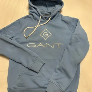 Ljusblå Gant hoddie i fint skick - Detta är som sagt en jättefin ljusblå Gant hoddie som jag säljer för att den är tyvärr för liten på mig. Inga defekter eller liknande. Bara att höra av sig om ni undrar något m.m.🩷