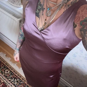 Fest klänning  - Vacker lila klänning, aldrig använd. Vilket är synd för ja tycker den är så fin i sin enkelhet. Passar till bröllop, student bal.. andra fina festligheter.  Storlek 40. 