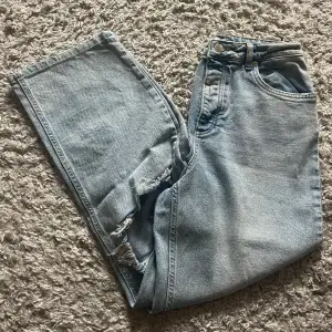 Aldrig använda raka ljusblå jeans från NA-KD i storlek 38 med hål och slitningar vid knäna! 