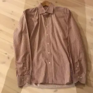 Randig Skjorta från Stenströms. Bra skick förutom då övre delen av kragen är lite sliten. Färg röd och vit. Storlek 41 Bra pris