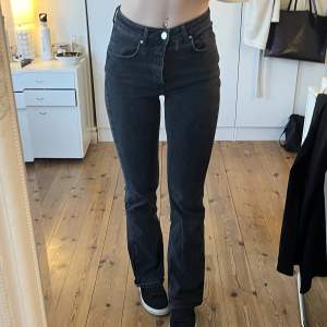 Svarta högmidjade jeans som är lite utsvängda. Storlek 26/32. Jag är 174 cm lång och brukar ha strl S/36. 
