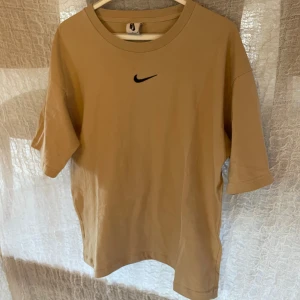 Nike center swoosh  - Helt sjuk nice T-shirt nu till sommaren. Center swoosh. Beige färg. Storlek L.