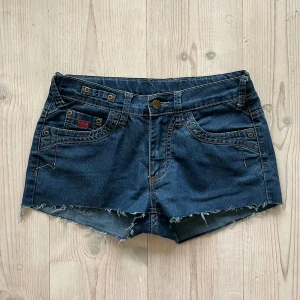 Lågmidjade jeansshorts - Lågmidjade jeansshorts från NYBO i storlek 38 som jag har klippt upp av ett par byxor. Passar S och M. Tvärs över midjan är det 38 cm + stretch och längs med sidan är det 24 cm. Använd gärna köp nu!