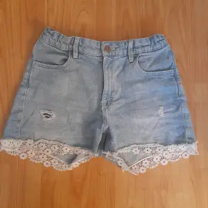 Ett par jätte söta jeans shorts med blommig spets kant ner till och går att dra åt i midjan om man inte vill ha ett skärp. Tyvärr så har den en liten fläk som man ser på sista bilden.