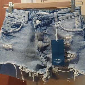 Sommar kläder  - 1: ljusblåa shorts stl36 helt nya 150kr 2:lång kjol i sammet me fransar.stl M 120kr 3:skojrta stl 170 kort ärmad 70kr 4:ed hardy klänning stl M 150kr 5: Klänning svart/vit me band som kan knytas åt både håll. Stl158/164 100kr 