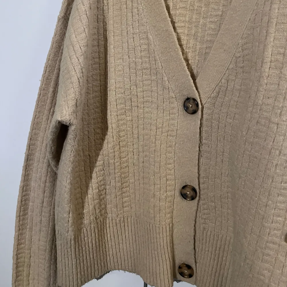 En jätte fin stickad begie långärmad tröja med 3 knappar som går att ha öppen eller stängd. Tröjan är köpt från lager 157 för 2 år sen ungefär och använd några få gånger . Stickat.