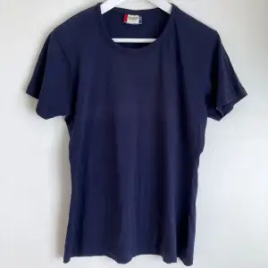 Klassisk marinblå figursydd t-shirt med stretch. Mått i cm: bröstvidd 49; axelbredd 41; längd fram från axeln 64; ärmlängd 17.