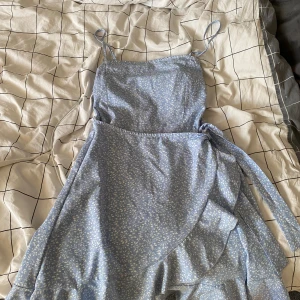 Ljusblå klänning - Ljusblå klänning med vita små blommor, knappt använd