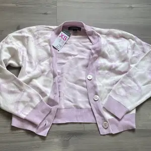 En tunn vit cardigan med lila/rosa fjärilar som är helt oanvänd🌸