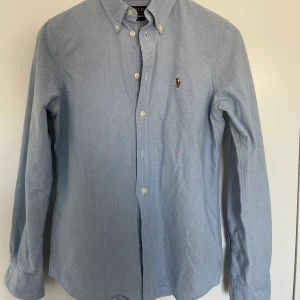 Polo Ralph Lauren skjorta - Säljer denna pga att den är för liten, kommer utan defekter. Ljusblå färg, härlig till sommaren. Aldrig använd, 10/10 skick. Nypris ligger på ca 1500.