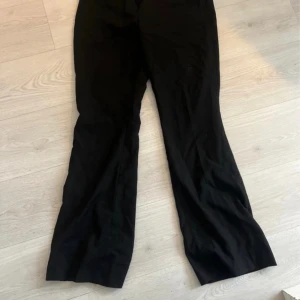 Lågmidjade utsvängda kostymbyxor  - Knappt använda lågmidjade utsvängda kostymbyxor. 