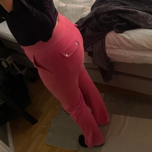 Rosa juicybyxor - Ett par rosa juicybyxor i storlek S❣️ byxorna är i hyfsat bra skick förutom några sminkfläckar på benet som jag inte lyckats få bort och några trådar som är lösa vid bakfickorna, därav priset🦄