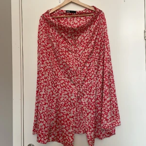 Blommig midikjol - Somrig midikjol med lite glansig material. Sparsamt använd.