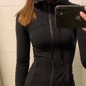 Lululemon define jacket - I princip oanvänd define jacket från lululemon. Det är den modellen med luva och i nulu materialet som är extremt mjukt. Den är slutsåld på hemsidan och väldigt populär.  Nypriset är 128 euro vilket motsvarar 1318 kr så jag säljer för 1000kr då den är helt ny💓 Storlek 0 vilket är minsta storleken