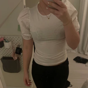 Vit t shirt me puffiga ärmar - T-shirt me puffärm jag köpte i sommar för att ha på min systers student men hade något annat så den kom aldrig till användning!💞 Jag är född 2007 och är ca 158 cm