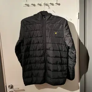 En svart Lyle & Scott i storlek 15/16 år (S). Nyskick på jackan då den är näst intill oanvänd! 